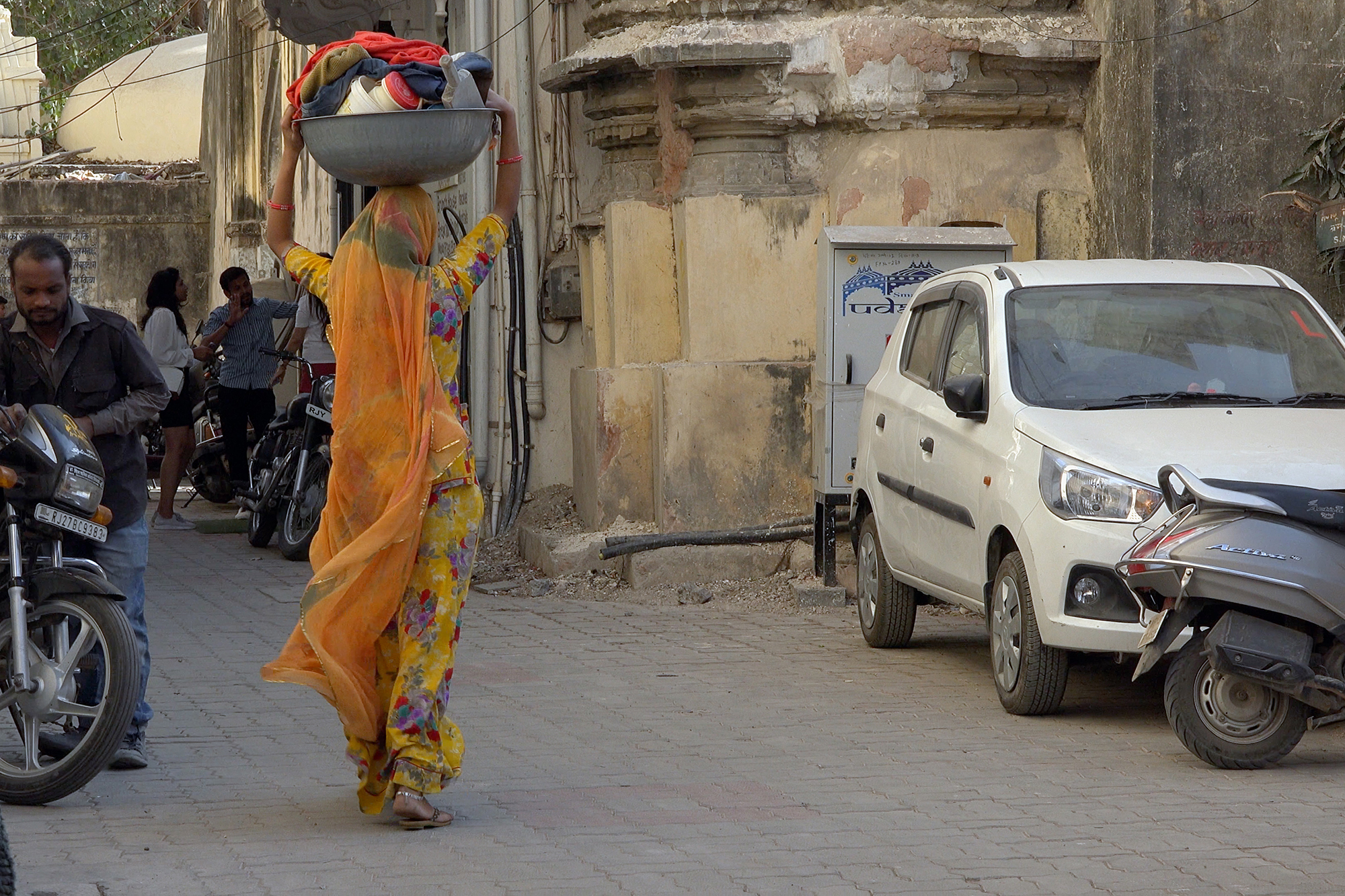 Christoph Radke, India, Udaipur, eine Frau mit einer Schüssel Wäsche auf dem Kopf, 2020